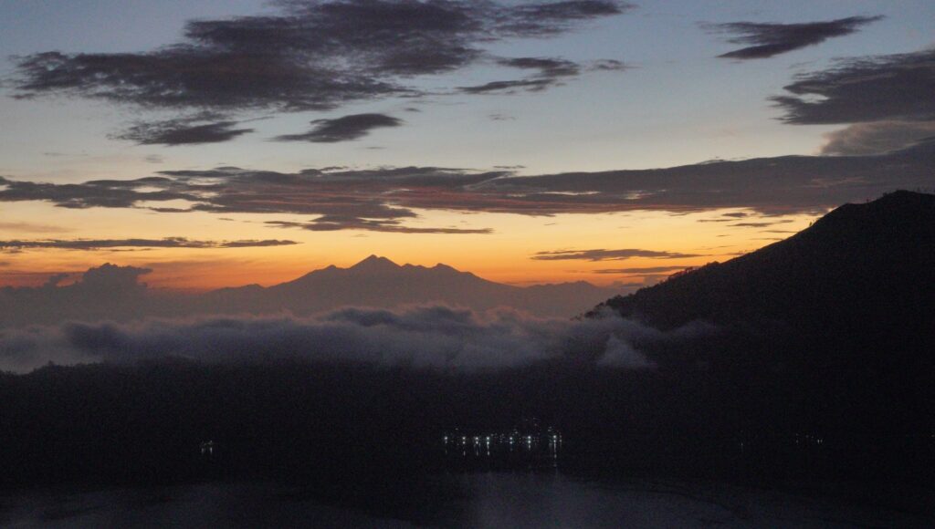Hikers trekking Mount Batur before sunrise with headlamps on the volcanic trail, Kintamani, Bali