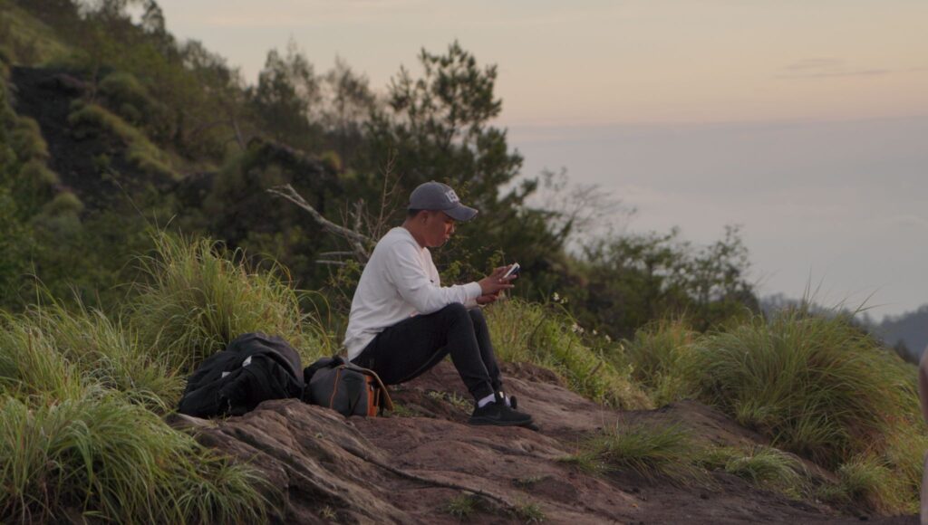 Hikers trekking Mount Batur before sunrise with headlamps on the volcanic trail, Kintamani, Bali